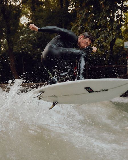 Sebastian Kuhn surft auf einer Welle auf dem Eisbach in München