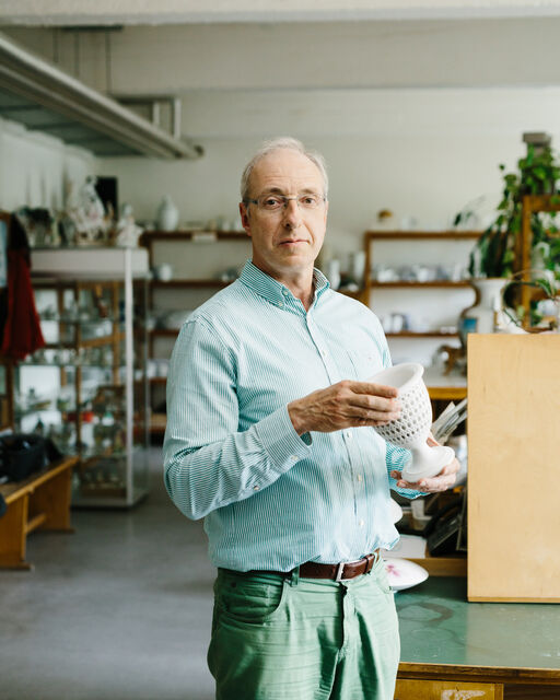 KPM Mitarbeiter Sascha Borowski im Atelier der KPM stehend und einen ANTIKEN ZUCKERKORB präsentierend