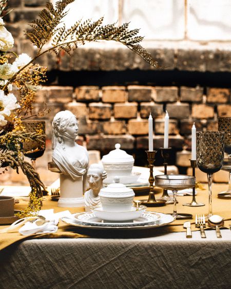 Eine Tafel gedeckt mit KPM-Porzellan und dekoriert mit Blumen und Kerzen