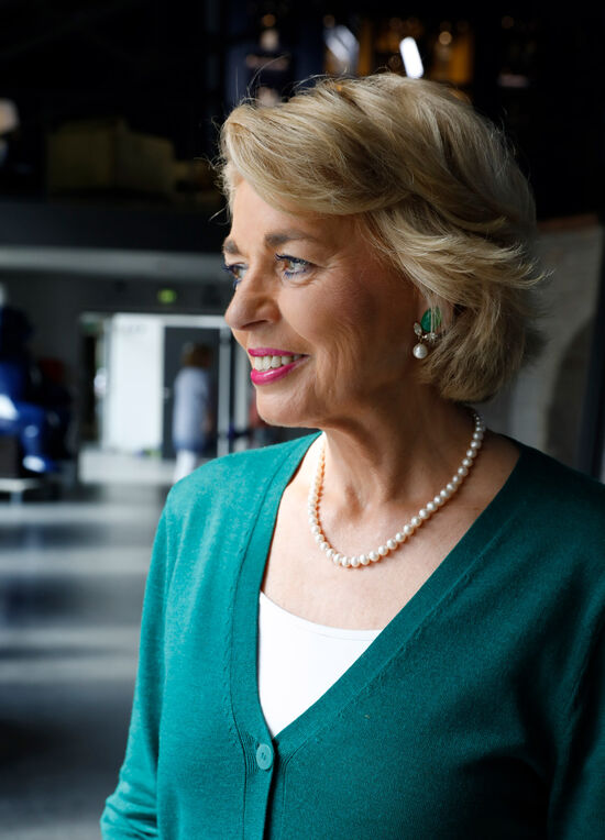 Jörg Woltmann spricht mit Tini Gräfin Rothirsch und Gerhard Schöningh über Investitionen und Engagement Porträt von Tini Gräfin Rothkirch im grünen Cardigan mit passenden grünen Ohrringen mit Perlenanhänger und Perlenkette