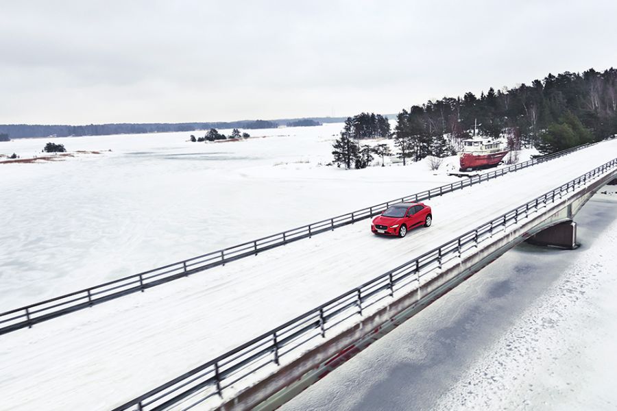 Klang der Stille: mit dem Jaguar I-PACE unterwegs in Finnland Der Jaguar I-Pace fährt auf einer verschneiten Brücke über den größten See Finnlands