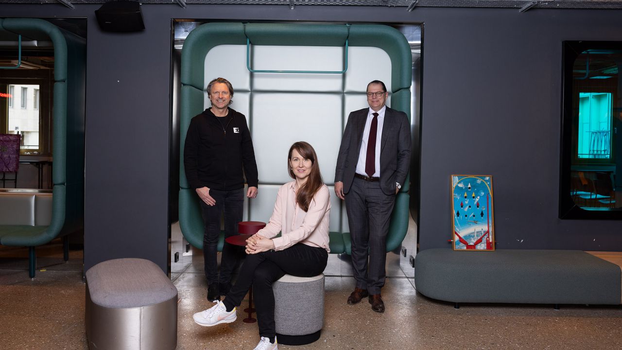 Zwei Männer und eine Frau in einem modern gestalteten Büroraum