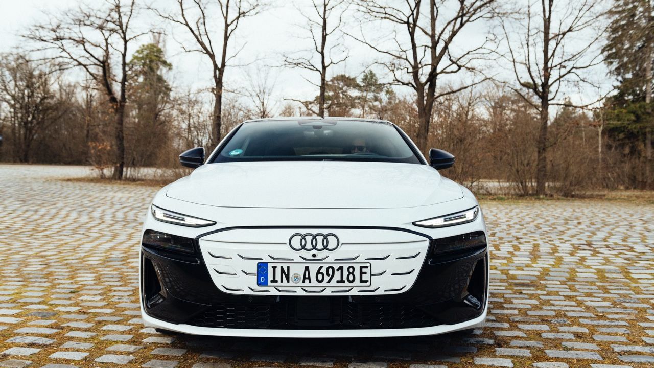 Frontalansicht eines weißen Audi A6 Sportback e-tron, der auf Kopfsteinpflaster parkt